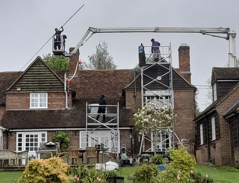 The Moss Cleaners using cherry picker and scaffolding to clean roof safely and professionally in New Alresford, Hampshire